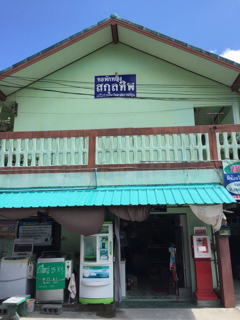 อาคารหอพักหญิงสกุลทิพ พร้อมป้ายชื่อหอพักและร้านค้าสะดวกซื้อชั้นล่าง